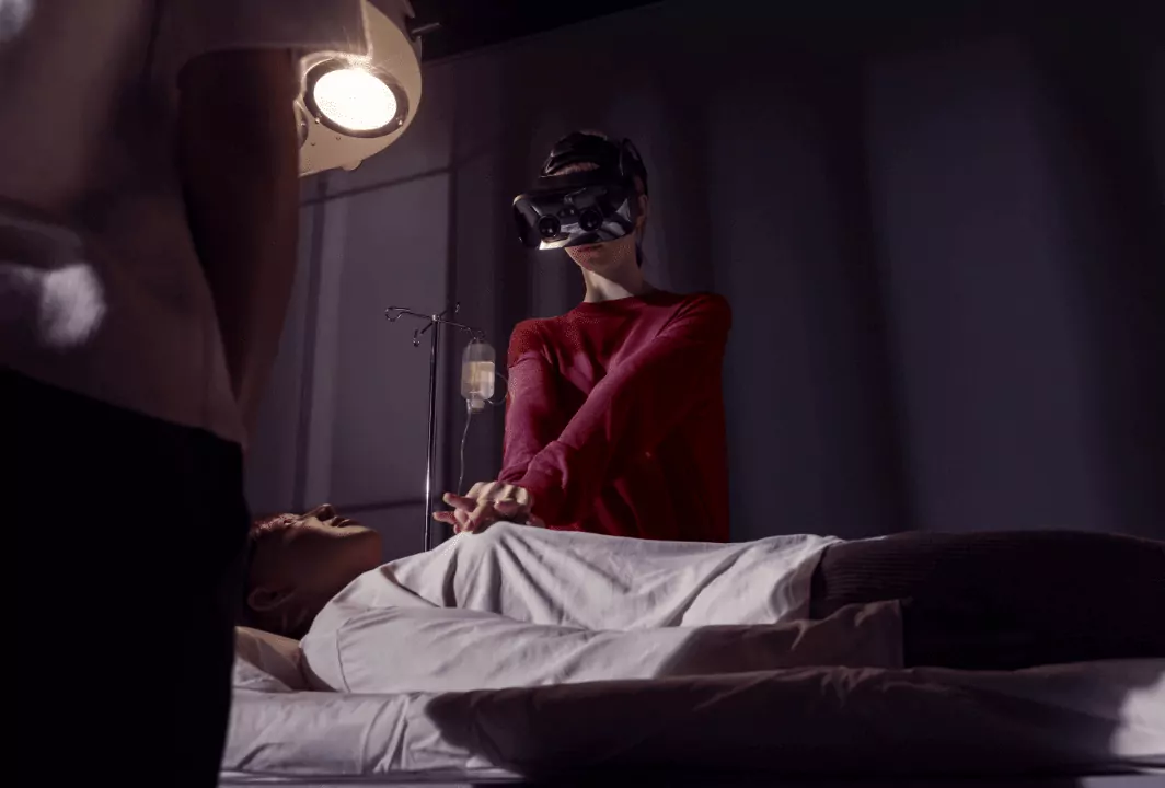 A woman in VR glasses treats a man